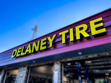 Delaney Tire and Auto in Monkey Junction, closeup of business name and open garage bays during the day
